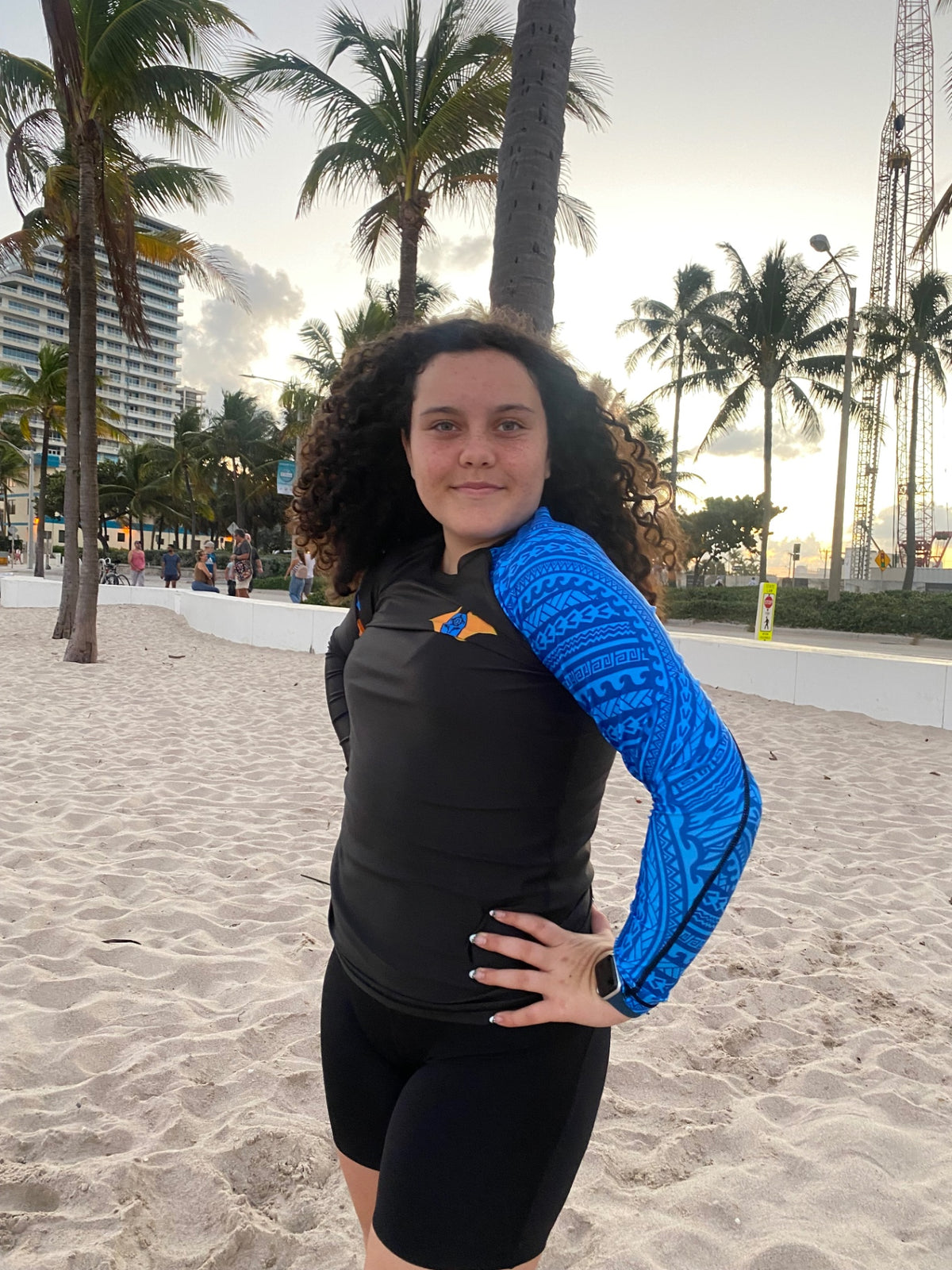 Ocean blue tribal sleeve rashguard front view under Maui palms